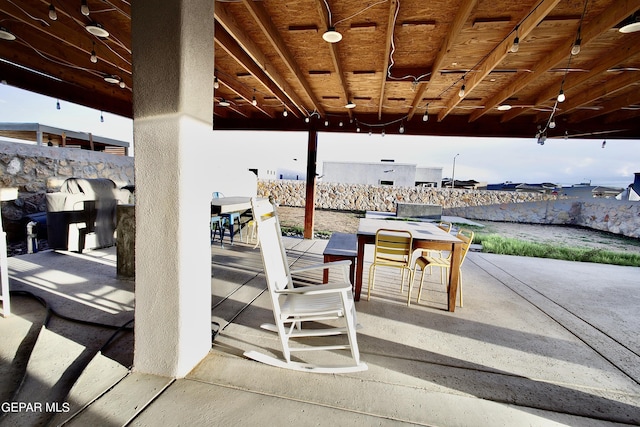 view of patio featuring outdoor dining space, outdoor dry bar, and fence