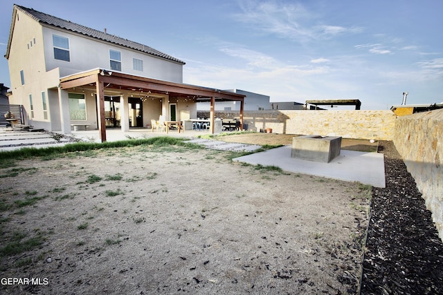 back of house with a fenced backyard, stucco siding, and a patio area