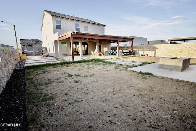 rear view of house featuring a fenced backyard, stucco siding, and a patio