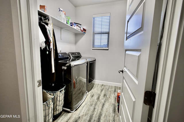 laundry room with independent washer and dryer, wood finished floors, laundry area, and baseboards
