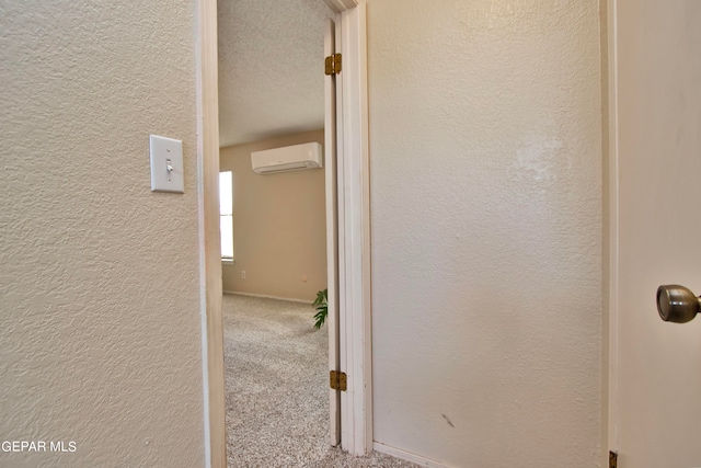 hallway with a wall mounted AC and carpet floors