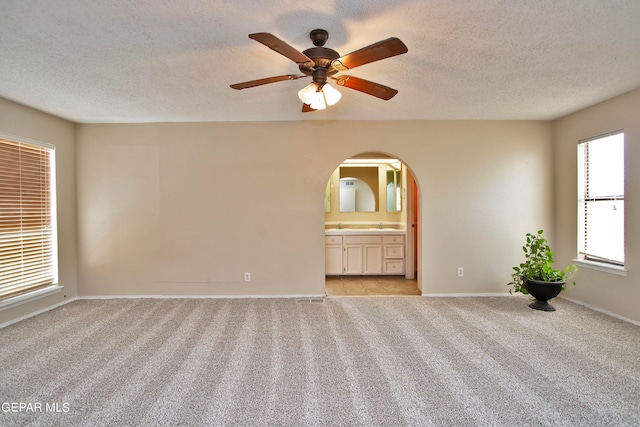 empty room featuring ceiling fan, a textured ceiling, and light tile patterned floors