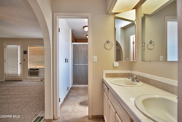 bathroom with a textured ceiling, tile patterned floors, dual vanity, and cooling unit