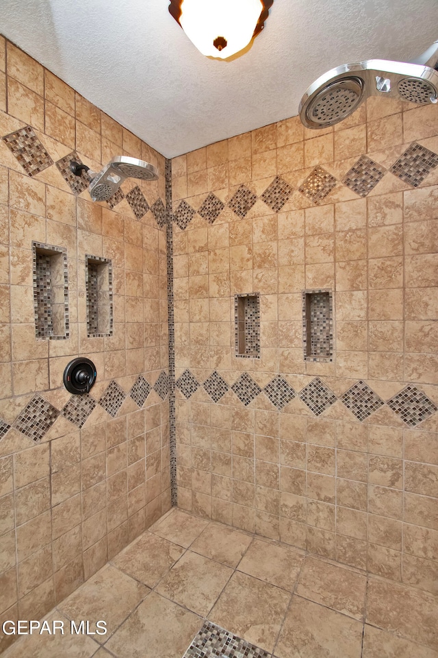 bathroom featuring a tile shower and a textured ceiling