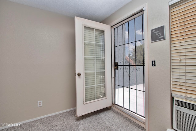 doorway to outside with a textured ceiling and carpet