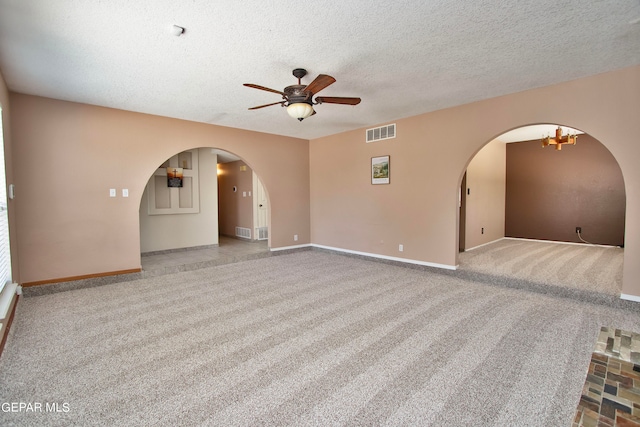 spare room featuring ceiling fan, a textured ceiling, and light carpet