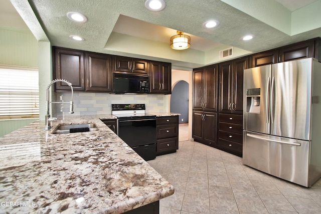 kitchen with a raised ceiling, stainless steel fridge with ice dispenser, electric stove, tasteful backsplash, and sink