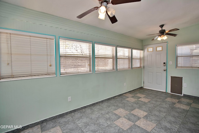 unfurnished sunroom with ceiling fan