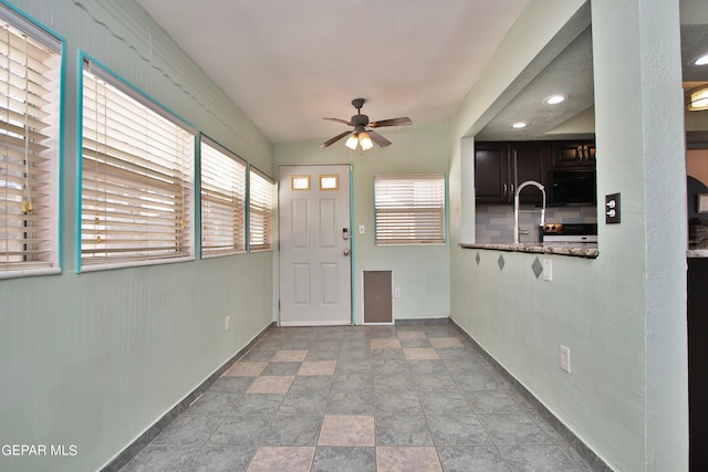 entryway featuring ceiling fan, light tile patterned floors, and a healthy amount of sunlight