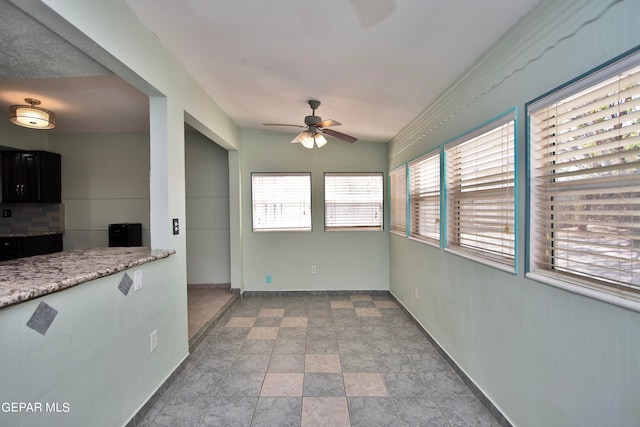 unfurnished sunroom with ceiling fan and a healthy amount of sunlight