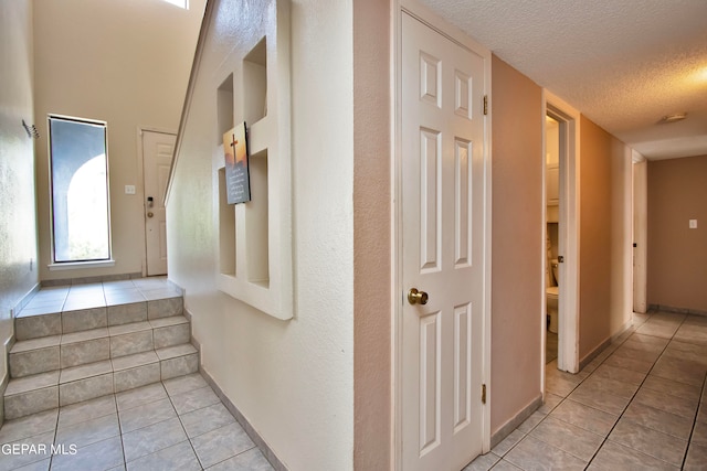 interior space featuring light tile patterned flooring and a textured ceiling