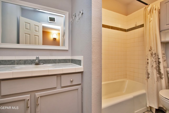 full bathroom featuring vanity, shower / bath combination with curtain, and toilet