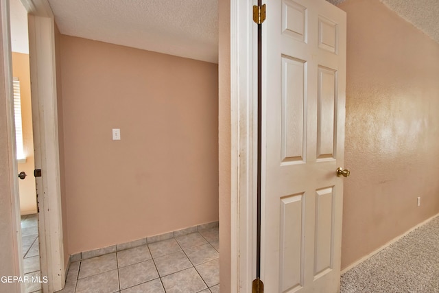 hallway with light tile patterned flooring and a textured ceiling