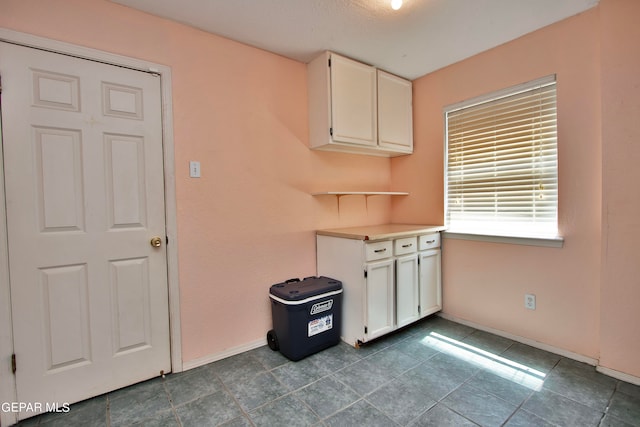 kitchen with white cabinets and tile patterned flooring