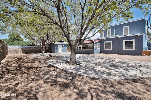 view of front facade featuring a patio area and a storage unit