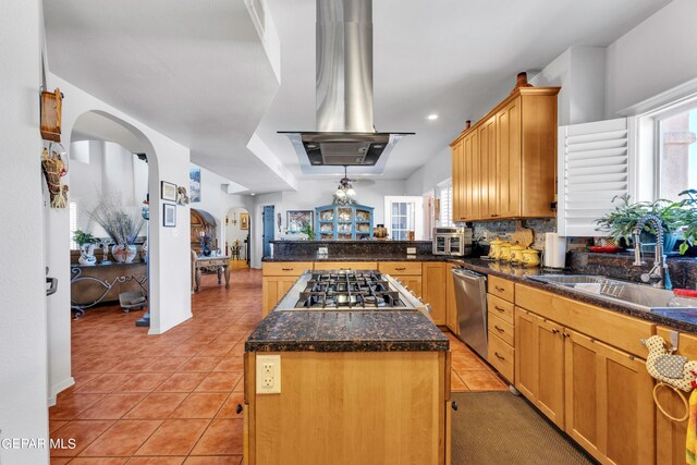 kitchen featuring light tile patterned floors, a center island, tasteful backsplash, and a healthy amount of sunlight