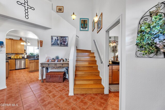 stairway featuring tile patterned flooring and a high ceiling