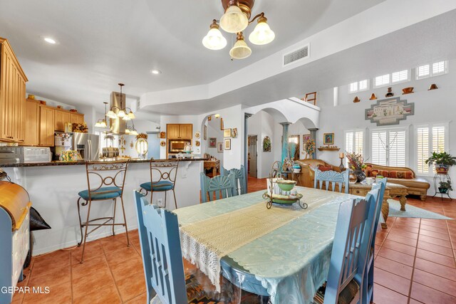 tiled dining area featuring a chandelier