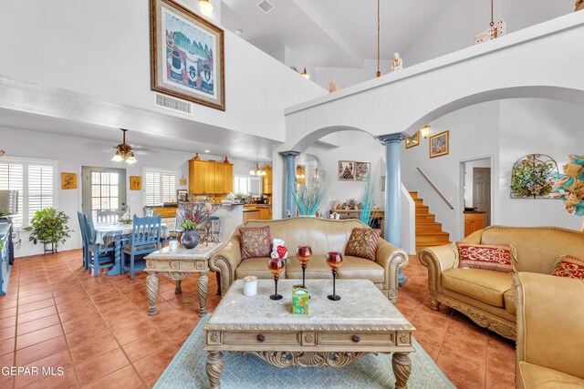 living room featuring light tile patterned floors, high vaulted ceiling, ceiling fan, and ornate columns