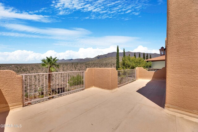 view of patio featuring a balcony and a mountain view