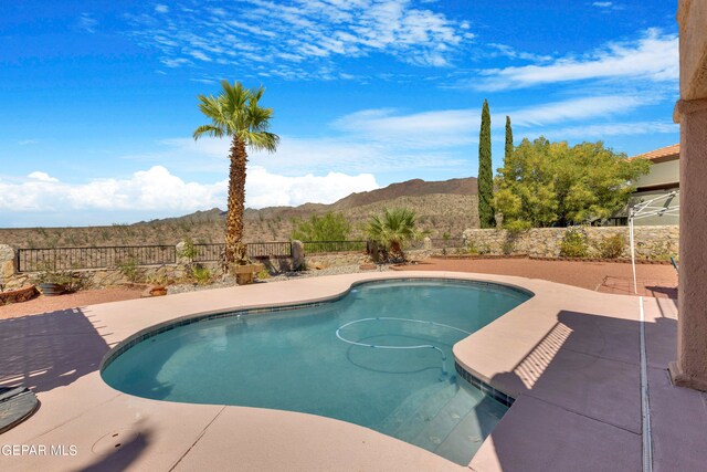 view of swimming pool with a mountain view and a patio