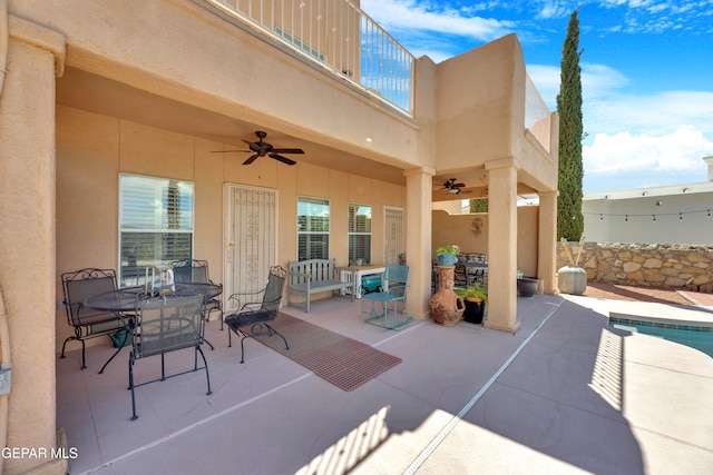 view of patio / terrace with ceiling fan and a balcony