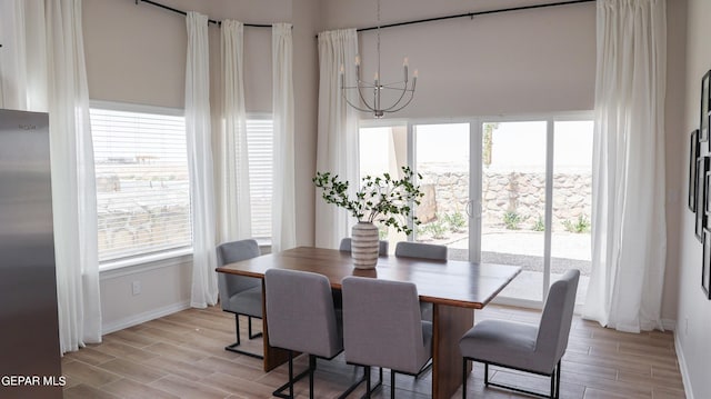 dining space with a notable chandelier and light wood-type flooring