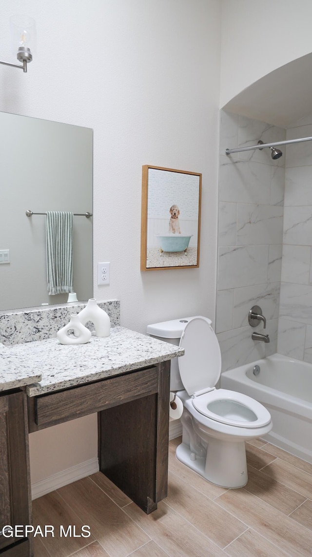 full bathroom with vanity, tiled shower / bath combo, and toilet