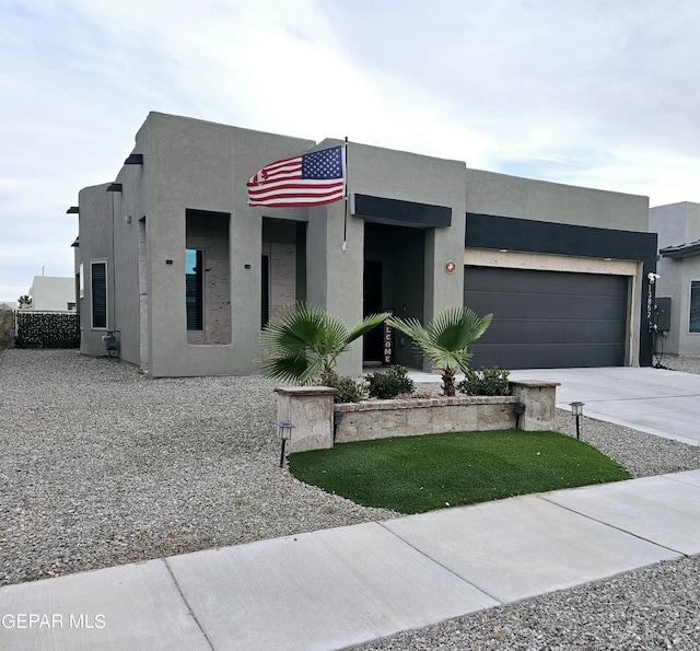 modern home featuring concrete driveway, an attached garage, and stucco siding