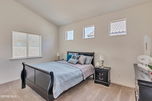 carpeted bedroom with lofted ceiling