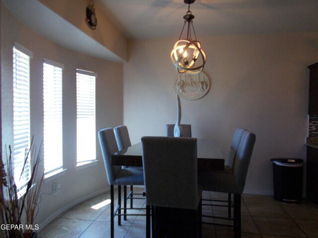 tiled dining room with plenty of natural light and an inviting chandelier