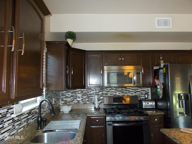 kitchen with appliances with stainless steel finishes, sink, dark brown cabinetry, and decorative backsplash