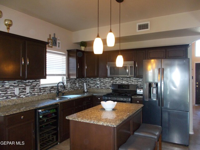 kitchen with tasteful backsplash, wine cooler, stainless steel appliances, and a kitchen island