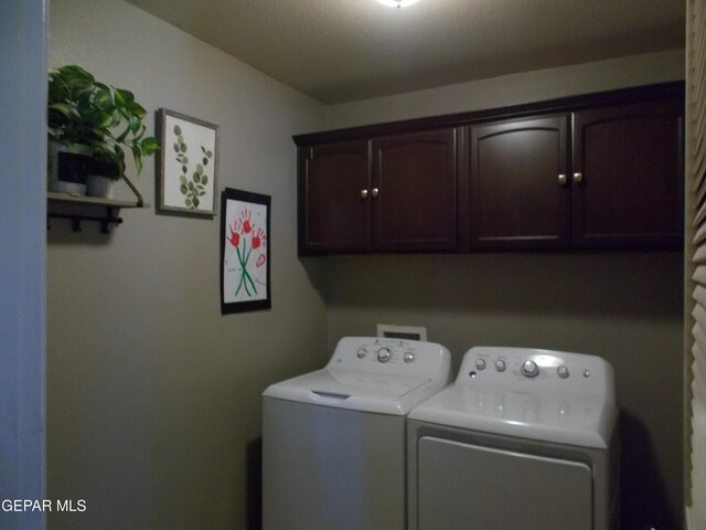 washroom with washing machine and dryer and cabinets