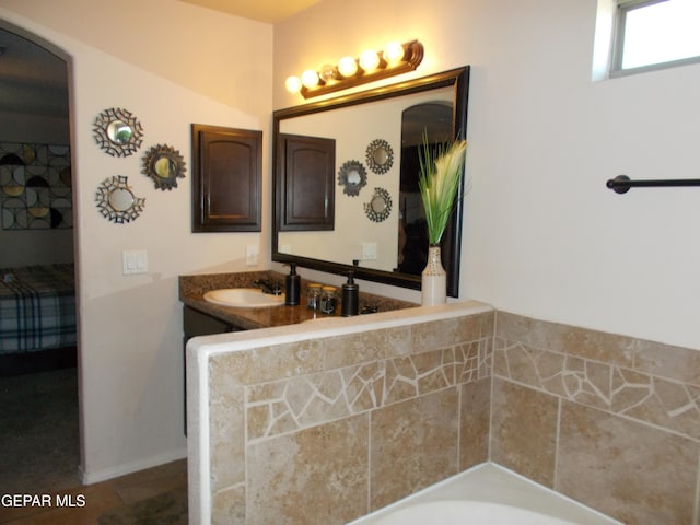 bathroom featuring tile patterned floors, vanity, and a washtub