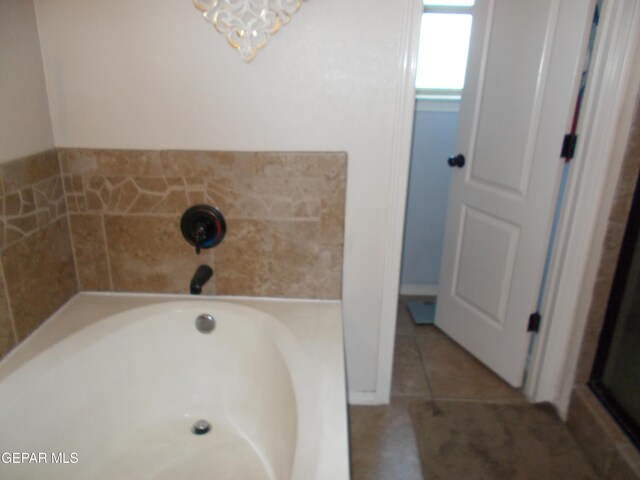 bathroom with a tub and tile patterned floors