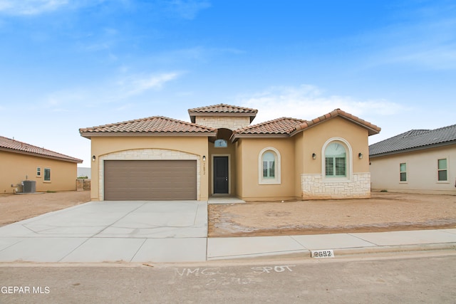 mediterranean / spanish house featuring central AC and a garage