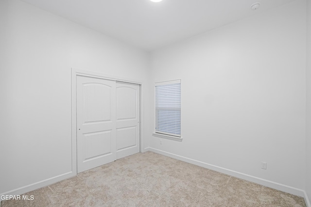 spare room featuring light carpet