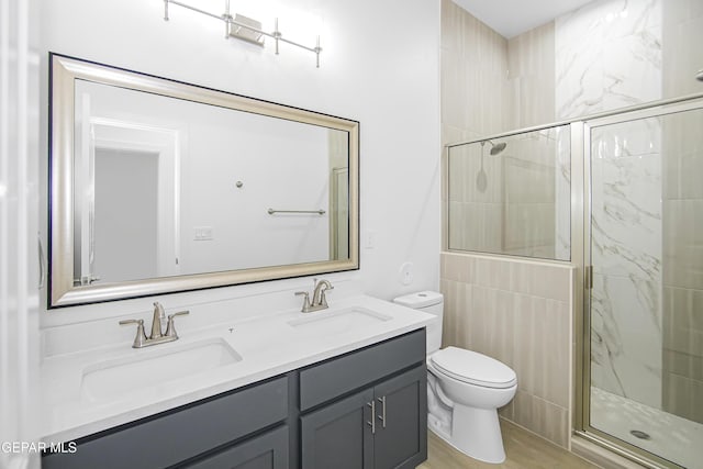 bathroom featuring vanity, hardwood / wood-style flooring, toilet, and a shower with shower door