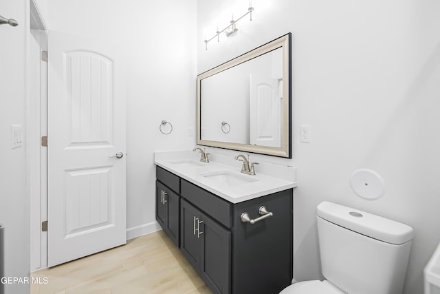 bathroom featuring toilet, vanity, and hardwood / wood-style flooring