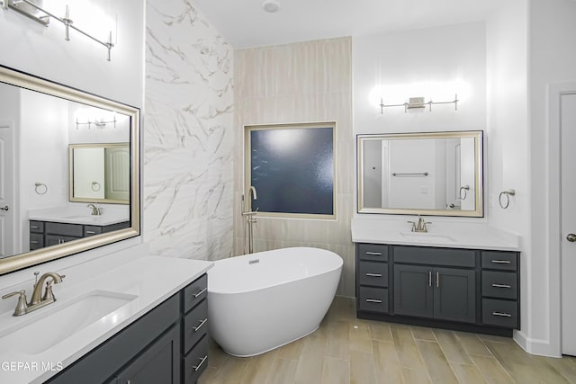 bathroom with vanity, tile walls, and a bathing tub