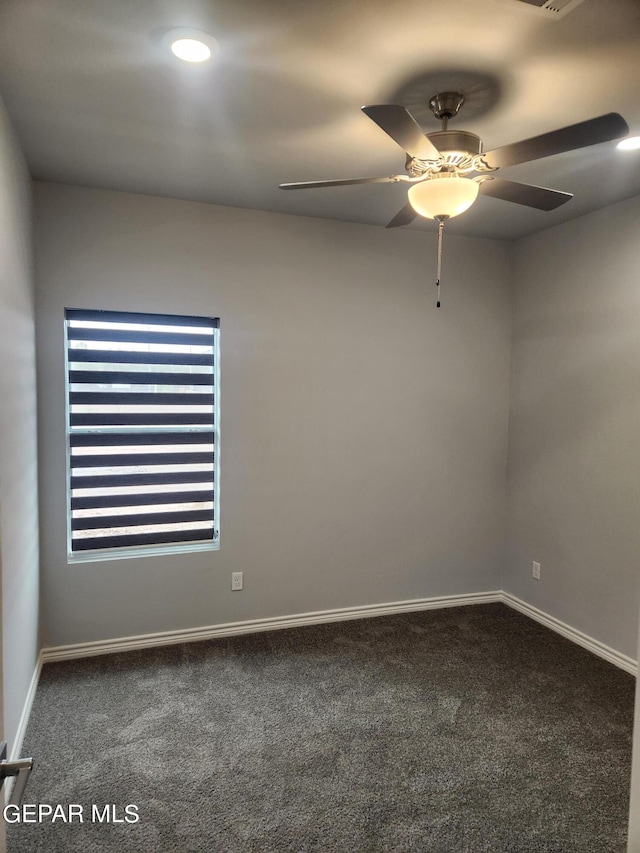 spare room with ceiling fan and carpet