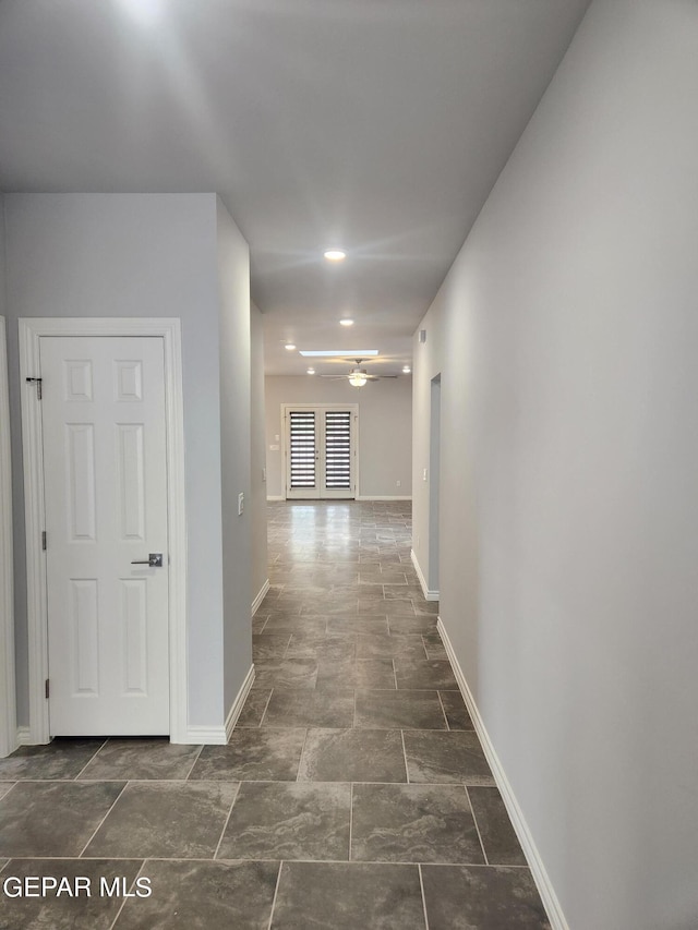 hall with dark tile patterned flooring