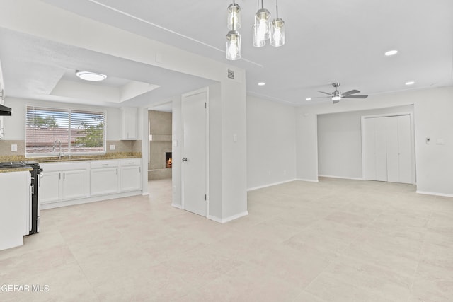 kitchen with stainless steel electric range oven, ceiling fan, light stone counters, pendant lighting, and white cabinets