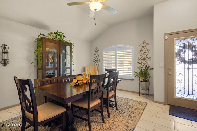 tiled dining space with ceiling fan and vaulted ceiling