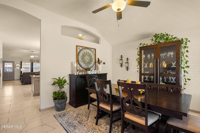 tiled dining area featuring ceiling fan and vaulted ceiling