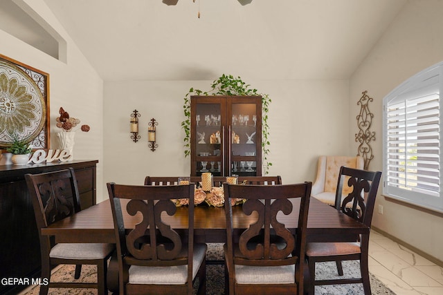 tiled dining room featuring ceiling fan and lofted ceiling