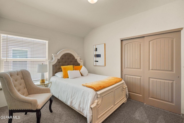 carpeted bedroom with a closet and lofted ceiling