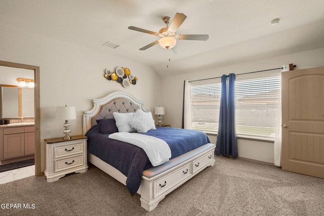 carpeted bedroom featuring ceiling fan, connected bathroom, sink, and lofted ceiling