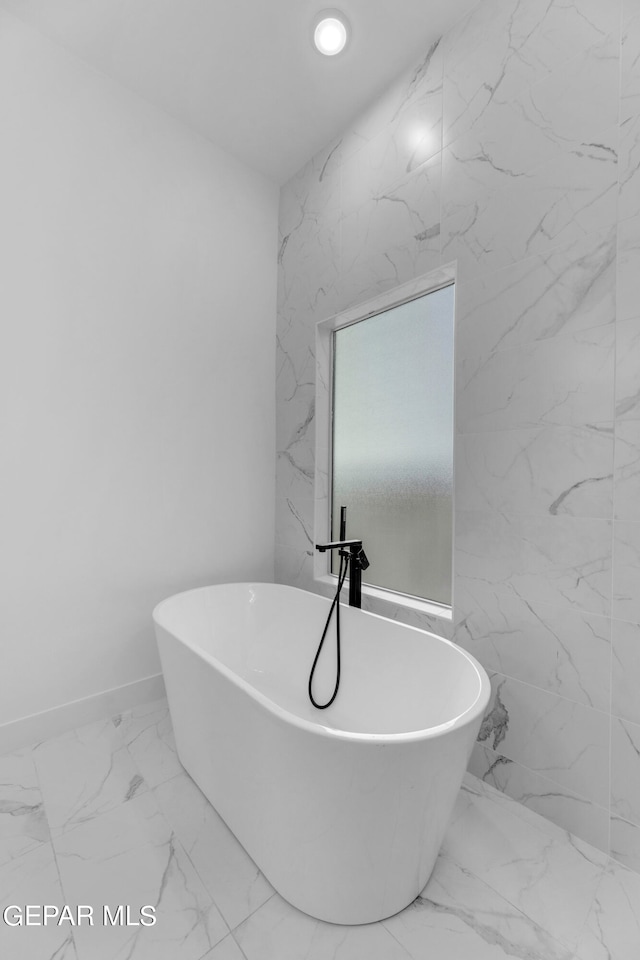 bathroom with tile walls, tile patterned floors, and a bathtub